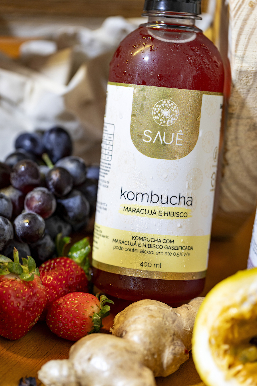 Foto de uma kombucha da Sauê com frutas ao redor